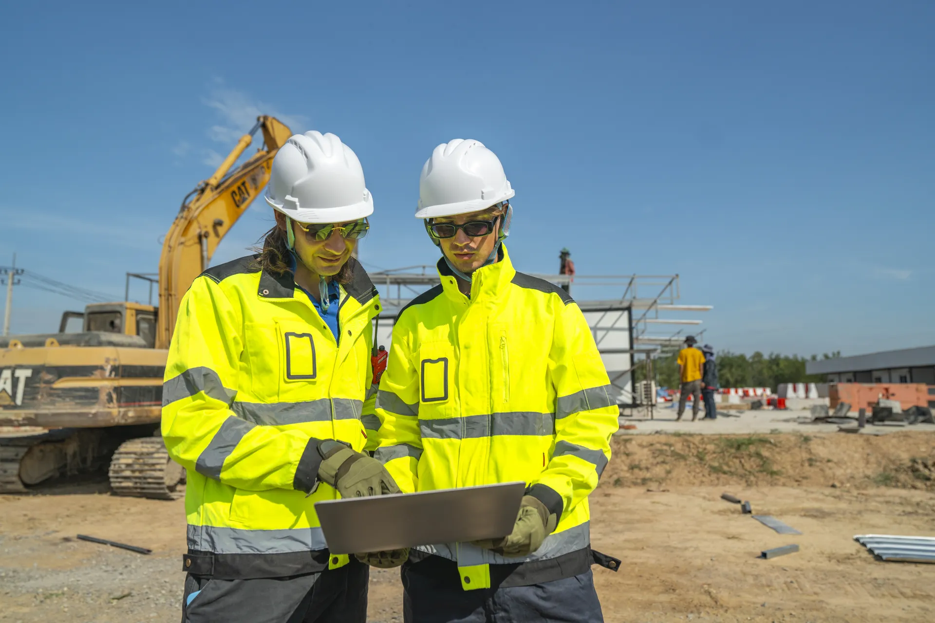 Artisans du bâtiment étudiant les plans d’un chantier