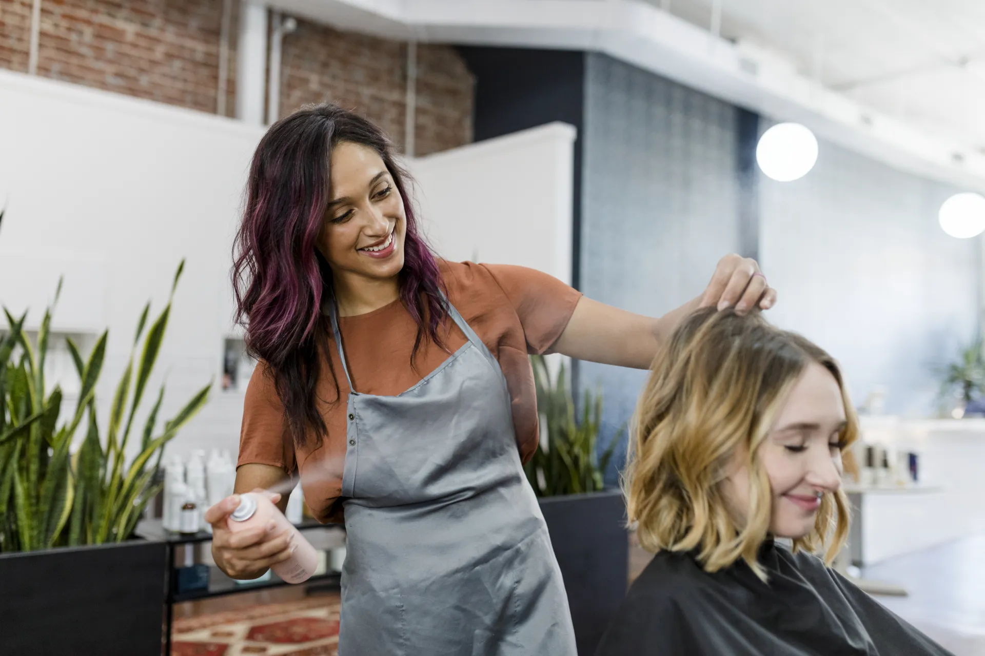 Coiffeuse accompagnant une cliente dans son salon