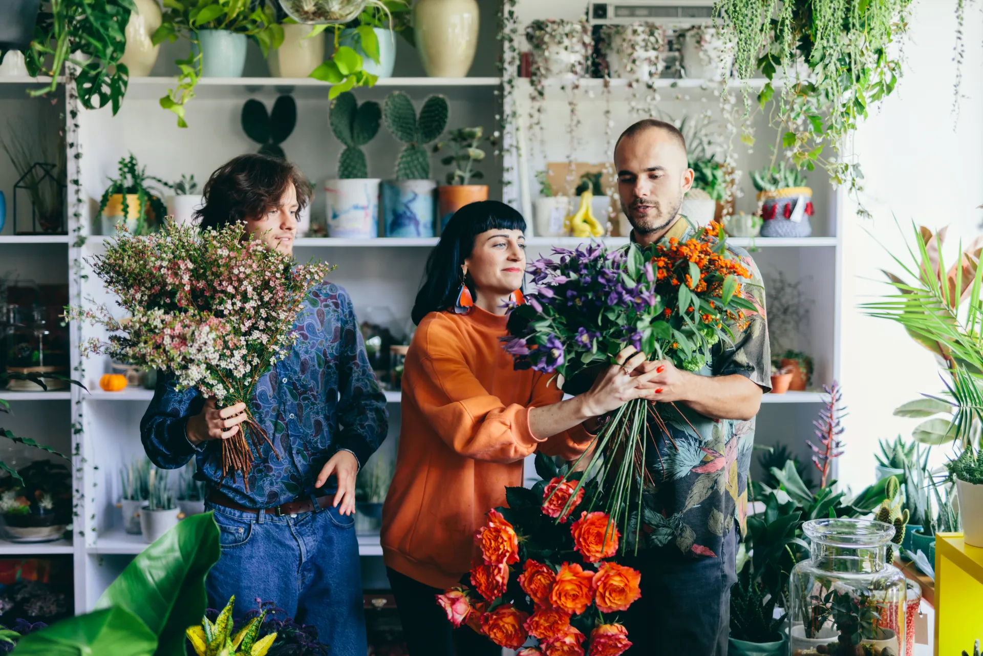 Équipe de fleuristes préparant des bouquets en boutique